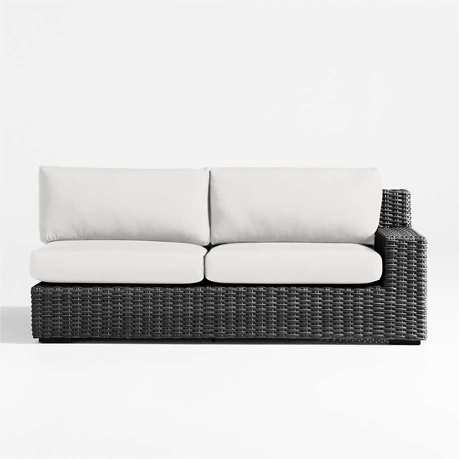 https://cb.scene7.com/is/image/Crate/AbacoCharRASofaWWhtSndCshSOSSS23/$web_pdp_main_carousel_med$/230301150635/abaco-charcoal-grey-resin-wicker-right-arm-outdoor-sofa-with-white-sand-sunbrella-cushions.jpg