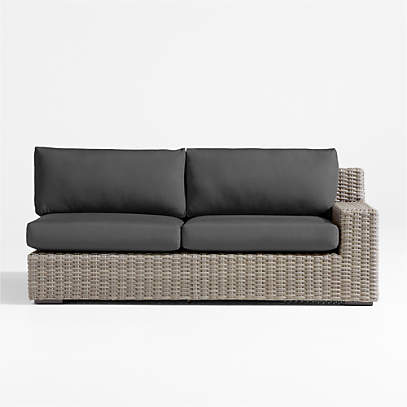 https://cb.scene7.com/is/image/Crate/AbacoRASofaWCharCshSOSSS23/$web_pdp_main_carousel_low$/230301170229/abaco-grey-resin-wicker-right-arm-outdoor-sofa-with-charcoal-sunbrella-cushions.jpg