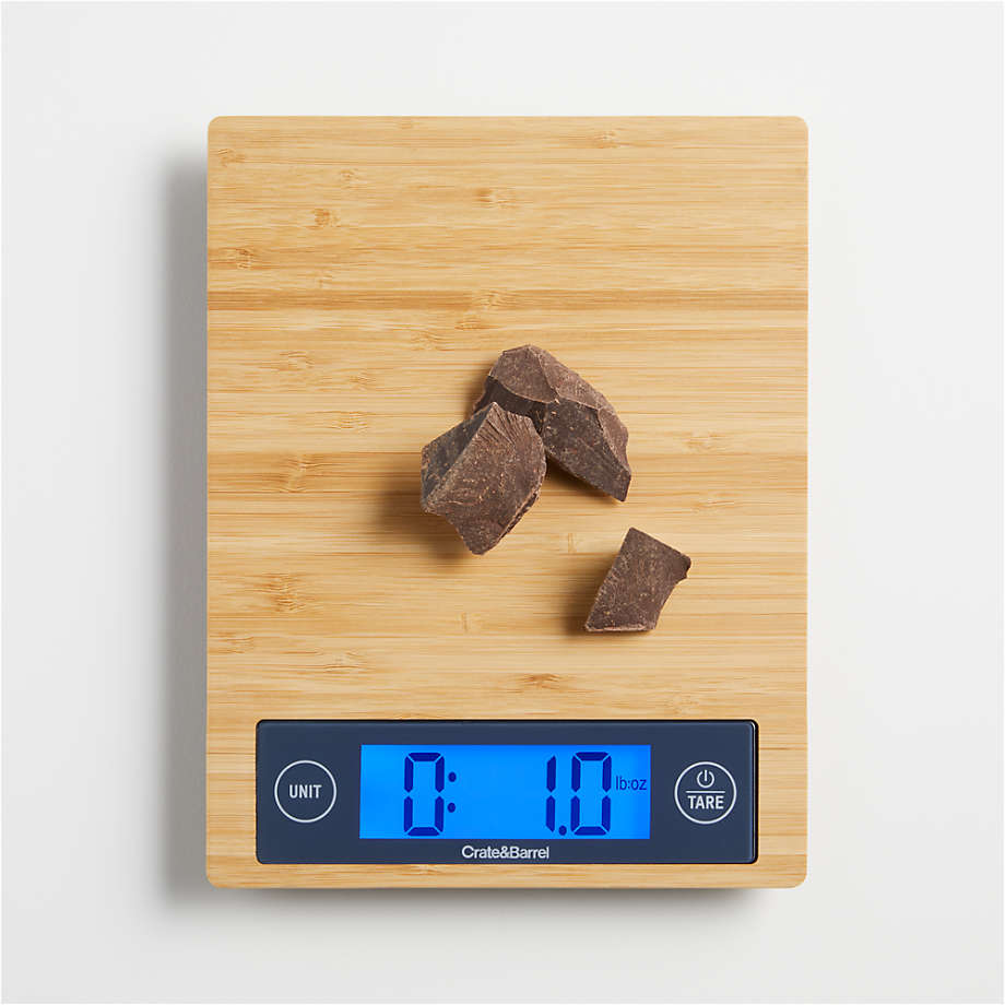 a brown bamboo kitchen scale with chocolate pieces on it