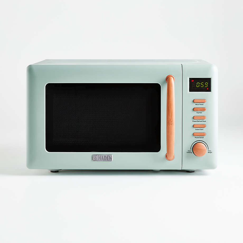 A mint green microwave with wooden accents