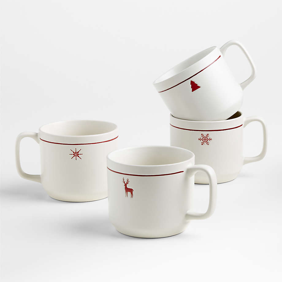 four white coffee mugs with holiday designs of a two snowflakes, a holiday tree, and a reindeer