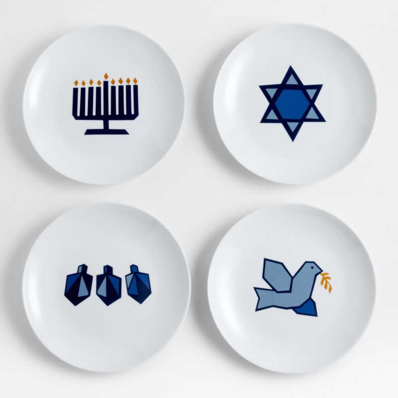 Four Hanukkah themed plates with blue illustrations on them