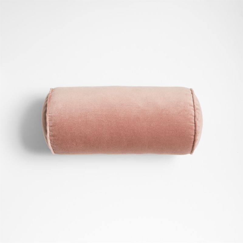 A pink velvet cylinder shaped throw pillow