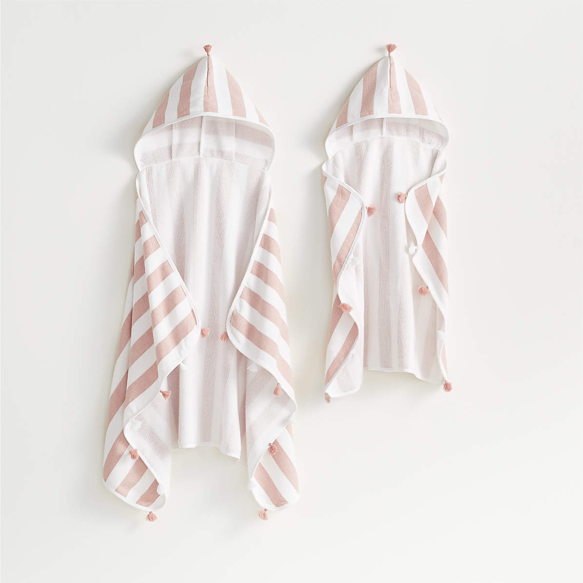 https://cb.scene7.com/is/image/Crate/StripedOrgHoodTowelsPinkFSSS21/$web_pdp_main_carousel_zoom_med$/210113134509/pink-striped-with-tassels-organic-turkish-hooded-towel.jpg