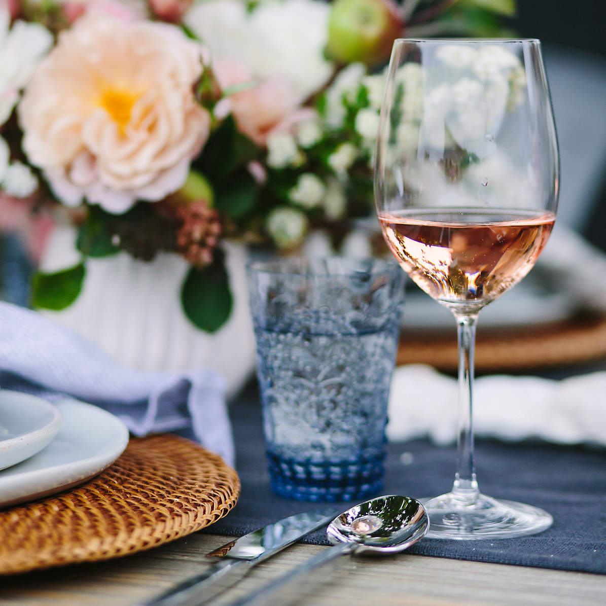 pair of different glass sizes and wines, red and white wine glasses on  wooden furniture table close up selective focus, vineyard farmhouse patio  view Photos