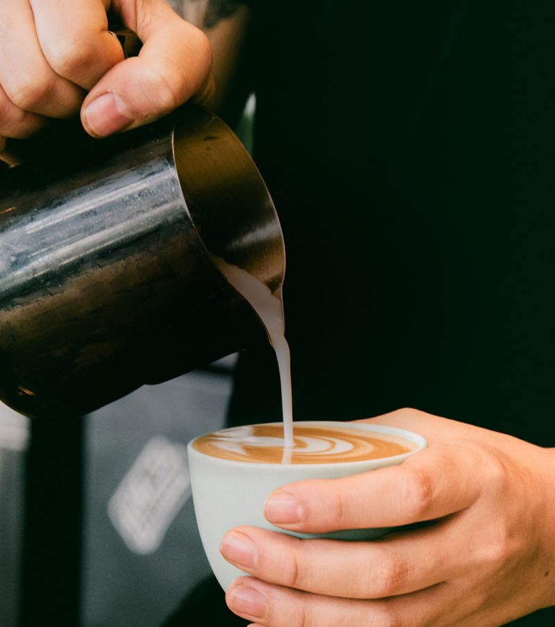 hands pouring coffee into cup