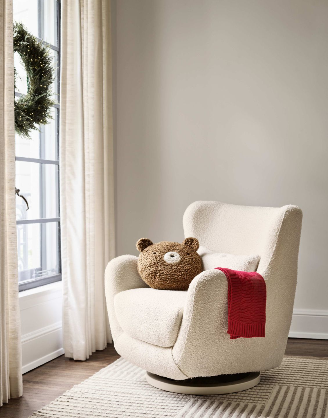 nursery chair with a blanket and throw pillow on it